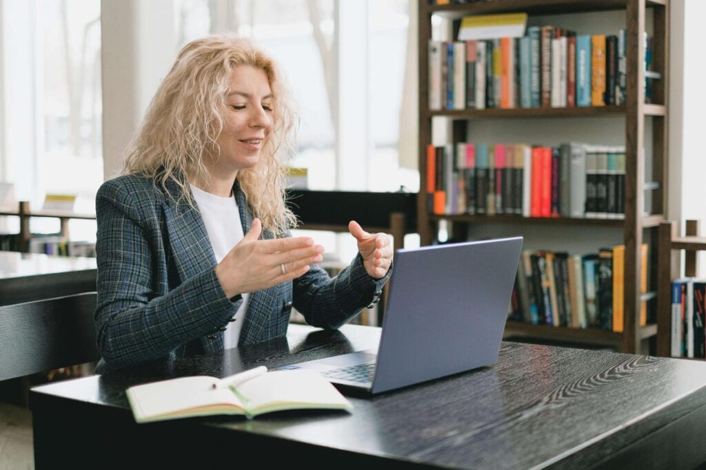 Professional woman having a virtual meeting on a laptop in a library setting